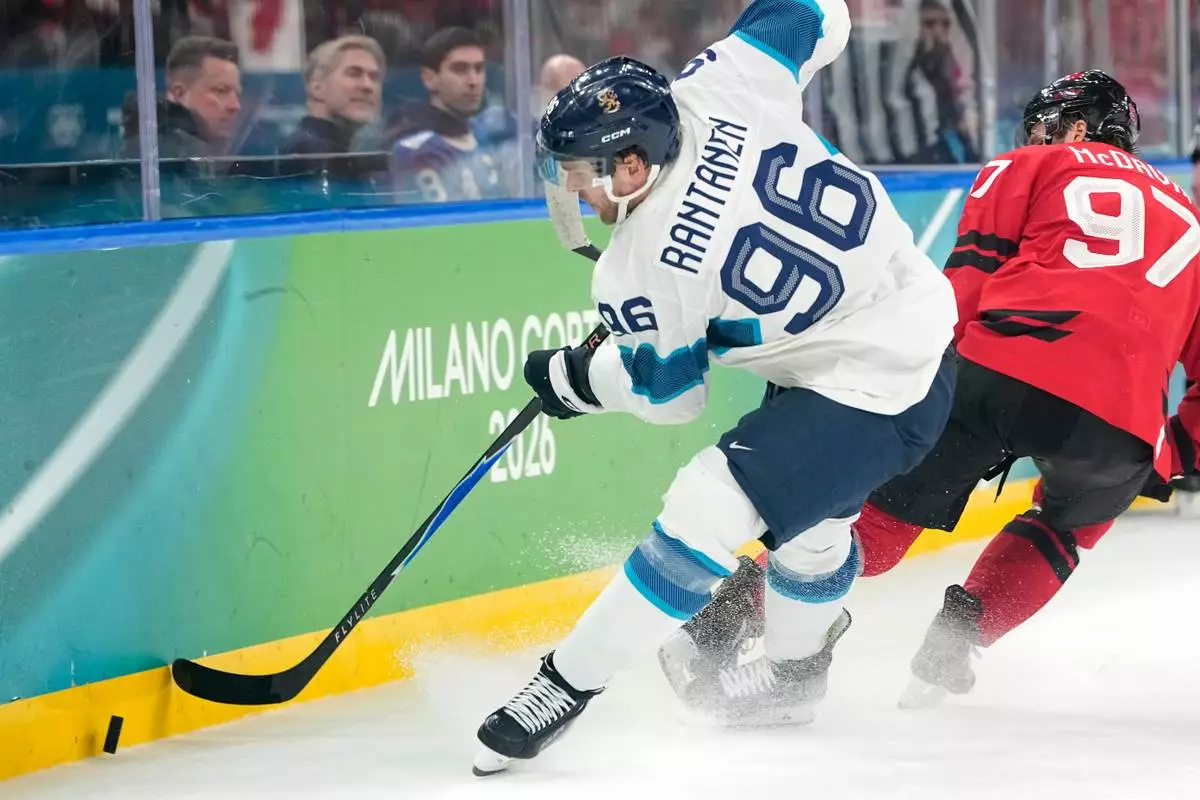 Finland's Mikko Rantanen (96) challenges with Canada's Connor McDavid (97) during a men's ice hockey semifinal game between Canada and Finland at the 2026 Winter Olympics, in Milan, Italy, Friday, Feb. 20, 2026. (AP Photo/Hassan Ammar)