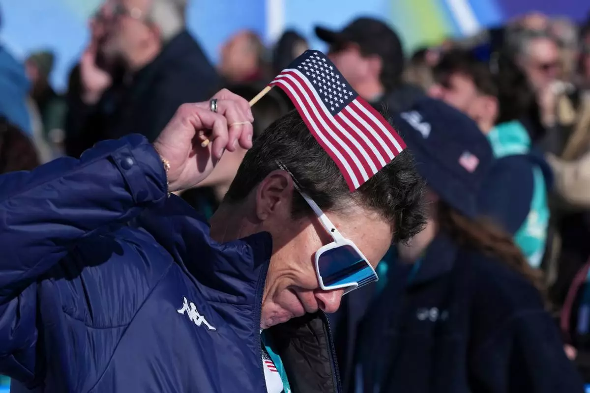 United States fans react following United States' Lindsey Vonn's crashed during an alpine ski women's downhill race, at the 2026 Winter Olympics, in Cortina d'Ampezzo, Italy, Sunday, Feb. 8, 2026. (AP Photo/Misper Apawu)