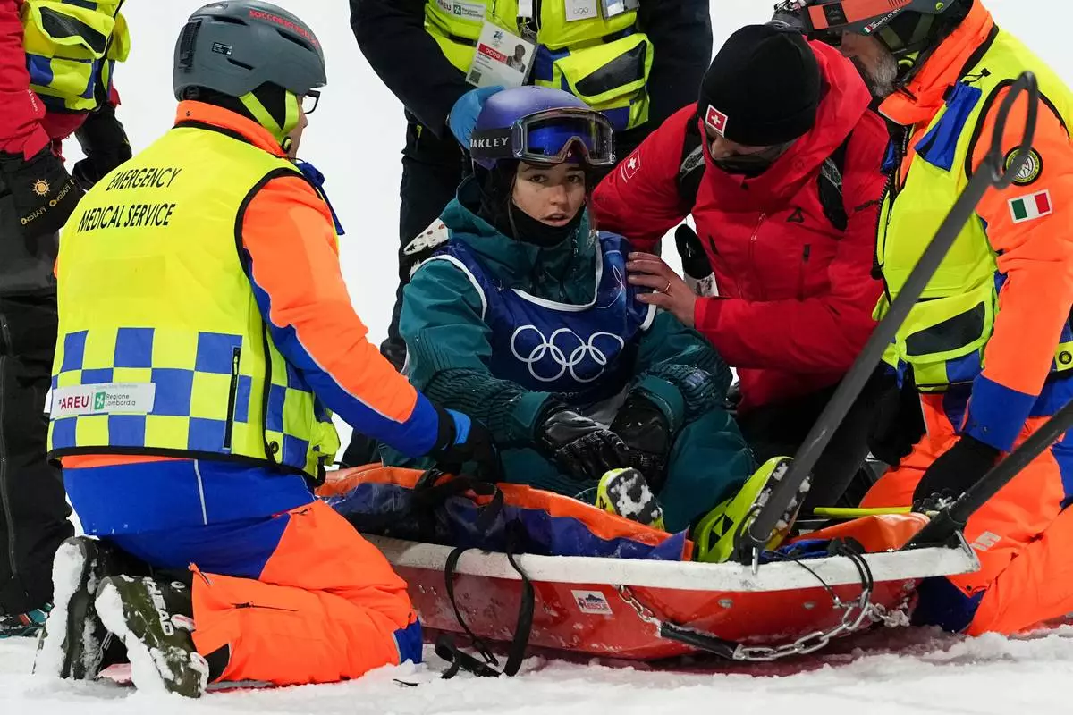 Medics tend to Switzerland's Mathilde Gremaud after she crashed during practice before the women's freestyle skiing big air finals at the 2026 Winter Olympics, in Livigno, Italy, Monday, Feb. 16, 2026. (AP Photo/Gregory Bull)