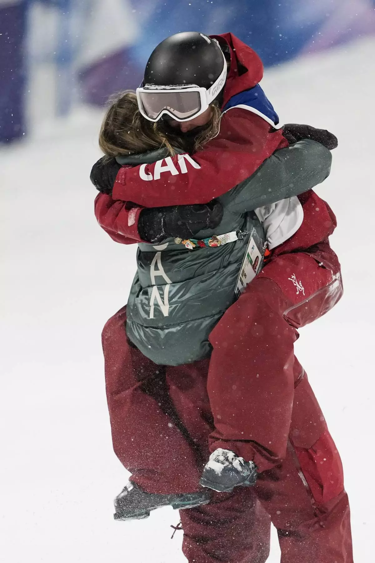 Gold medalist Canada's Megan Oldham hugs a teammate after winning the women's freestyle skiing big air finals at the 2026 Winter Olympics, in Livigno, Italy, Monday, Feb. 16, 2026. (AP Photo/Lindsey Wasson)