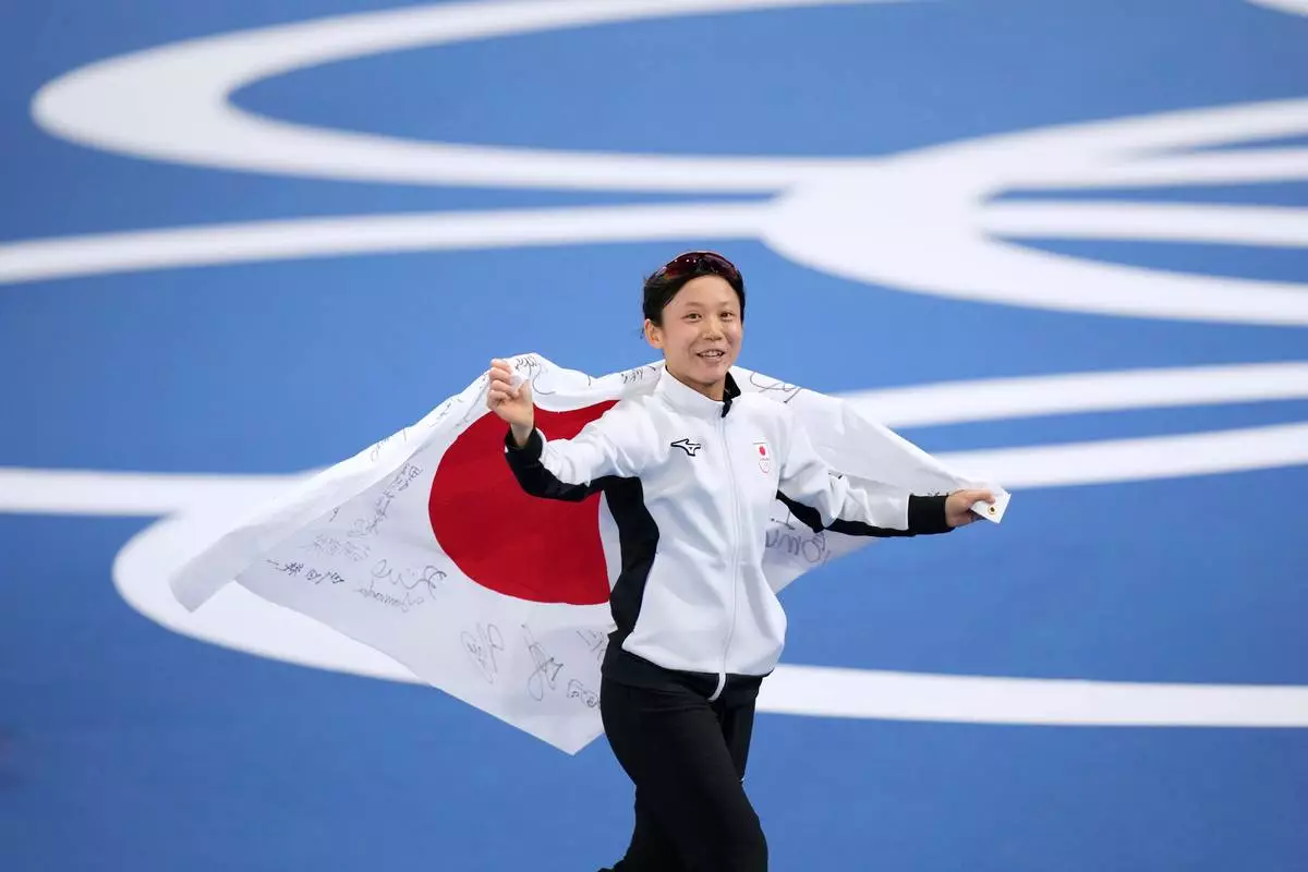 Miho Takagi of Japan celebrates winning the bronze medal in the women's 500 meters speedskating race at the 2026 Winter Olympics, in Milan, Italy, Sunday, Feb. 15, 2026. (AP Photo/Luca Bruno)