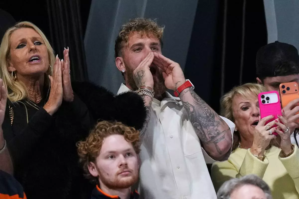 Jake Paul of the U.S. screams as his fiancée Jutta Leerdam of the Netherlands celebrates with her silver medal on the podium of the women's 500 meters speedskating race at the 2026 Winter Olympics, in Milan, Italy, Sunday, Feb. 15, 2026. (AP Photo/Antonio Calanni)