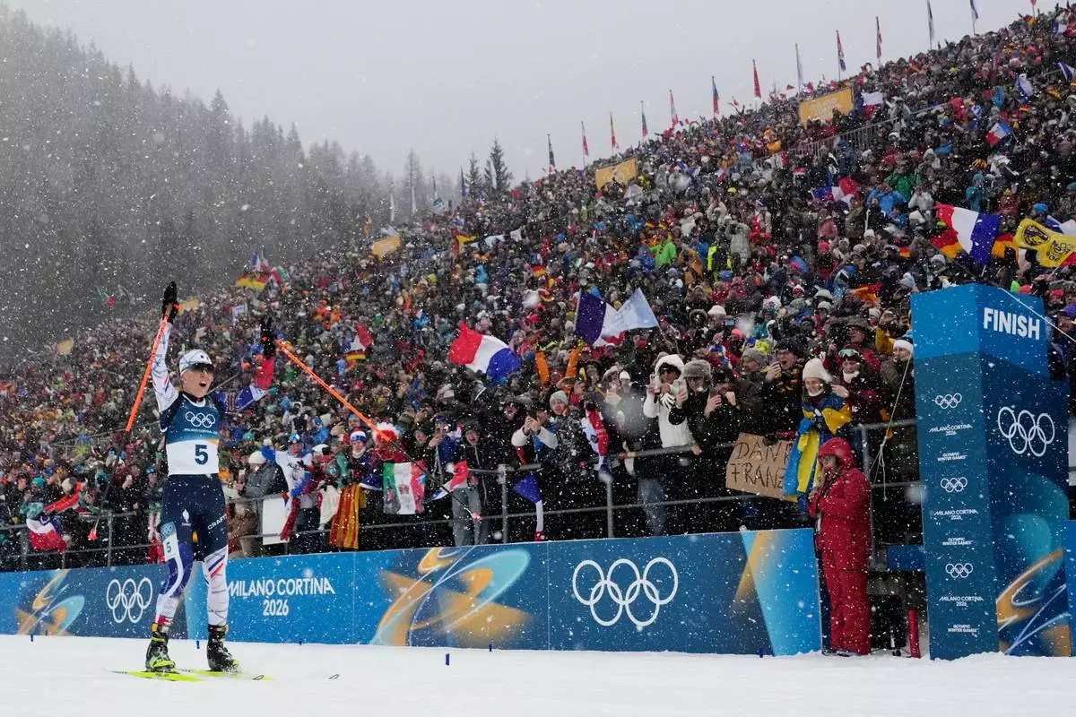 Oceane Michelon, of France, skis to the finish line for gold in the women's 12.5-kilometer mass start biathlon race at the 2026 Winter Olympics in Anterselva, Italy, Saturday, Feb. 21, 2026. (AP Photo/David J. Phillip)