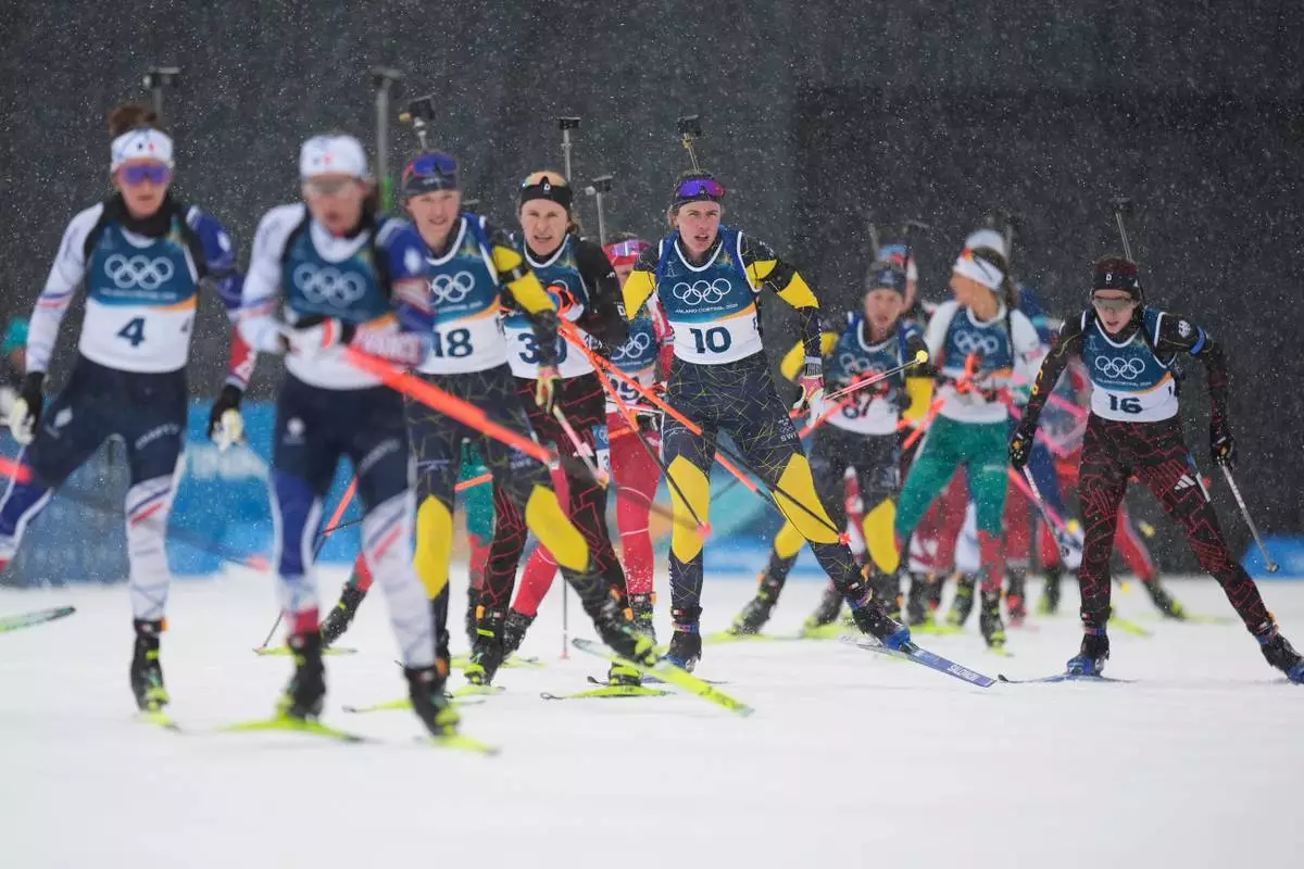 Elvira Oeberg, of Sweden, center, skis with other athletes into the shooting range in the women's 12.5-kilometer mass start biathlon race at the 2026 Winter Olympics in Anterselva, Italy, Saturday, Feb. 21, 2026. (AP Photo/Andrew Medichini)