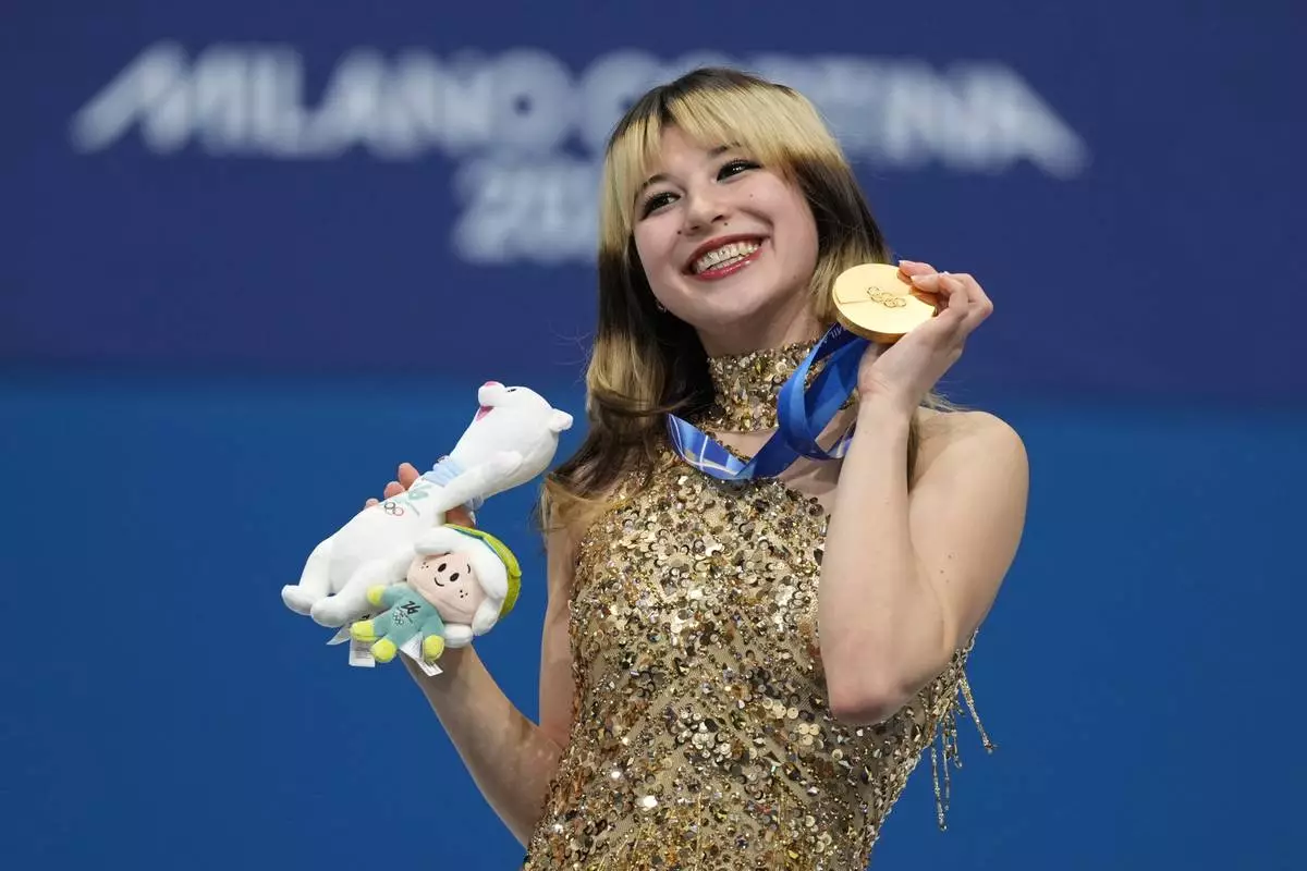 Gold medalist Alysa Liu of the United States displays her medal after competing in the women's free skate program in figure skating at the 2026 Winter Olympics, in Milan, Italy, Thursday, Feb. 19, 2026. (AP Photo/Stephanie Scarbrough)