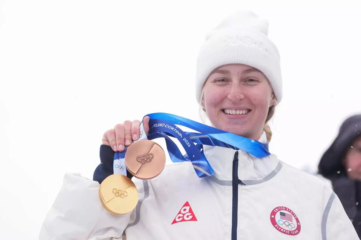 Bronze medalist United States' Elizabeth Lemley wears her gold medal alongside her bronze medal after the women's freestyle skiing dual moguls finals at the 2026 Winter Olympics, in Livigno, Italy, Saturday, Feb. 14, 2026. Lemley won the gold medal in women's moguls earlier this week. (AP Photo/Lindsey Wasson)