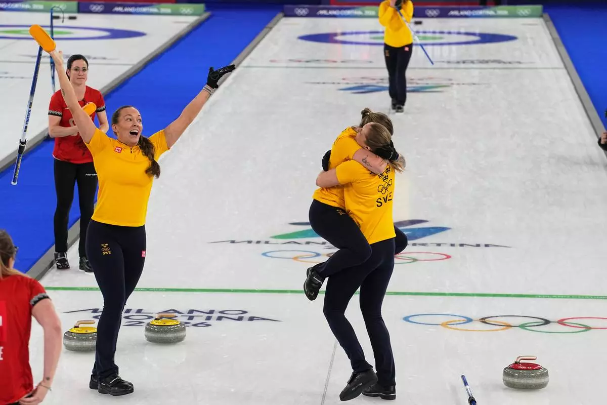 Team Sweden celebrates defeating Switzerland to win a women's curling gold medal match, at the 2026 Winter Olympics, in Cortina d'Ampezzo, Italy, Sunday, Feb. 22, 2026.(AP Photo/Fatima Shbair)