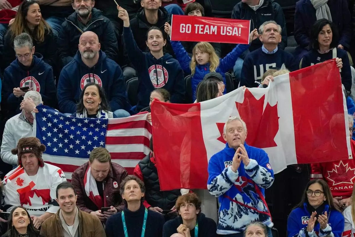Spectators cheer on the United States and Canada during the men's ice hockey gold medal game at the 2026 Winter Olympics, in Milan, Italy, Sunday, Feb. 22, 2026. (AP Photo/Luca Bruno)