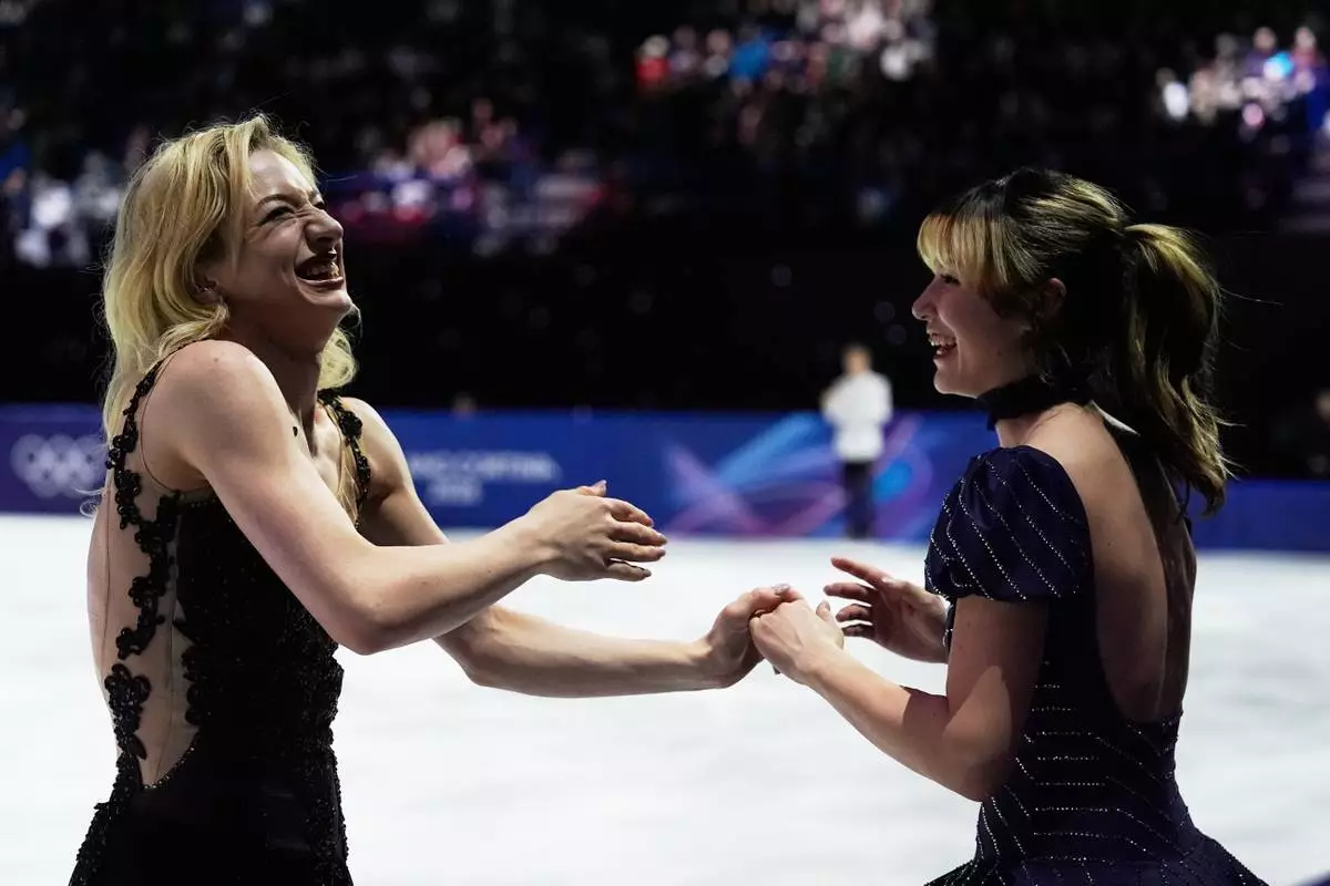 From left, Amber Glenn and Alysa Liu of the United States react after performing in the figure skating exhibition at the 2026 Winter Olympics, in Milan, Italy, Saturday, Feb. 21, 2026. (AP Photo/Ashley Landis)