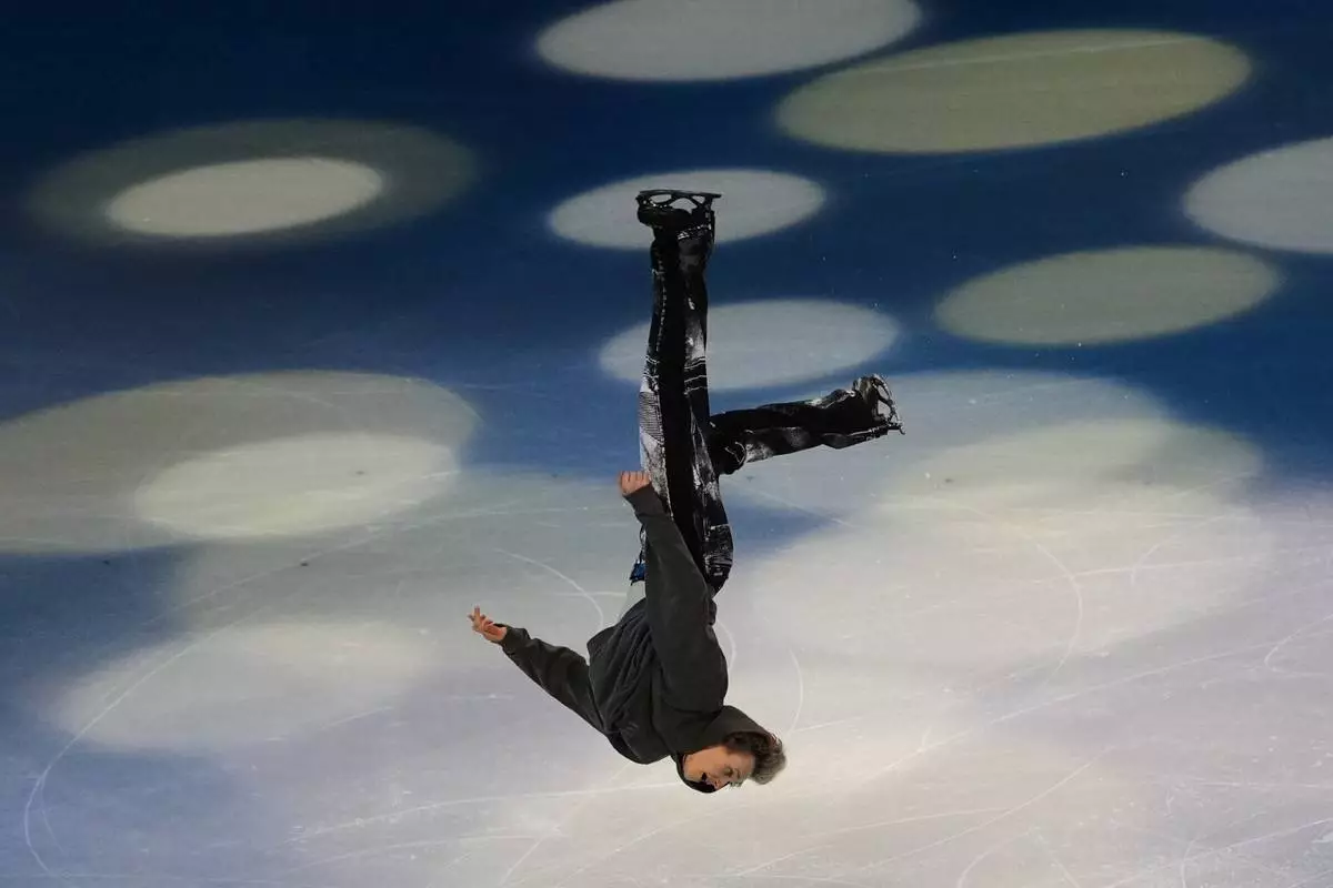Ilia Malinin of the United States does a back flip during his performance in the figure skating exhibition at the 2026 Winter Olympics, in Milan, Italy, Saturday, Feb. 21, 2026. (AP Photo/Francisco Seco)