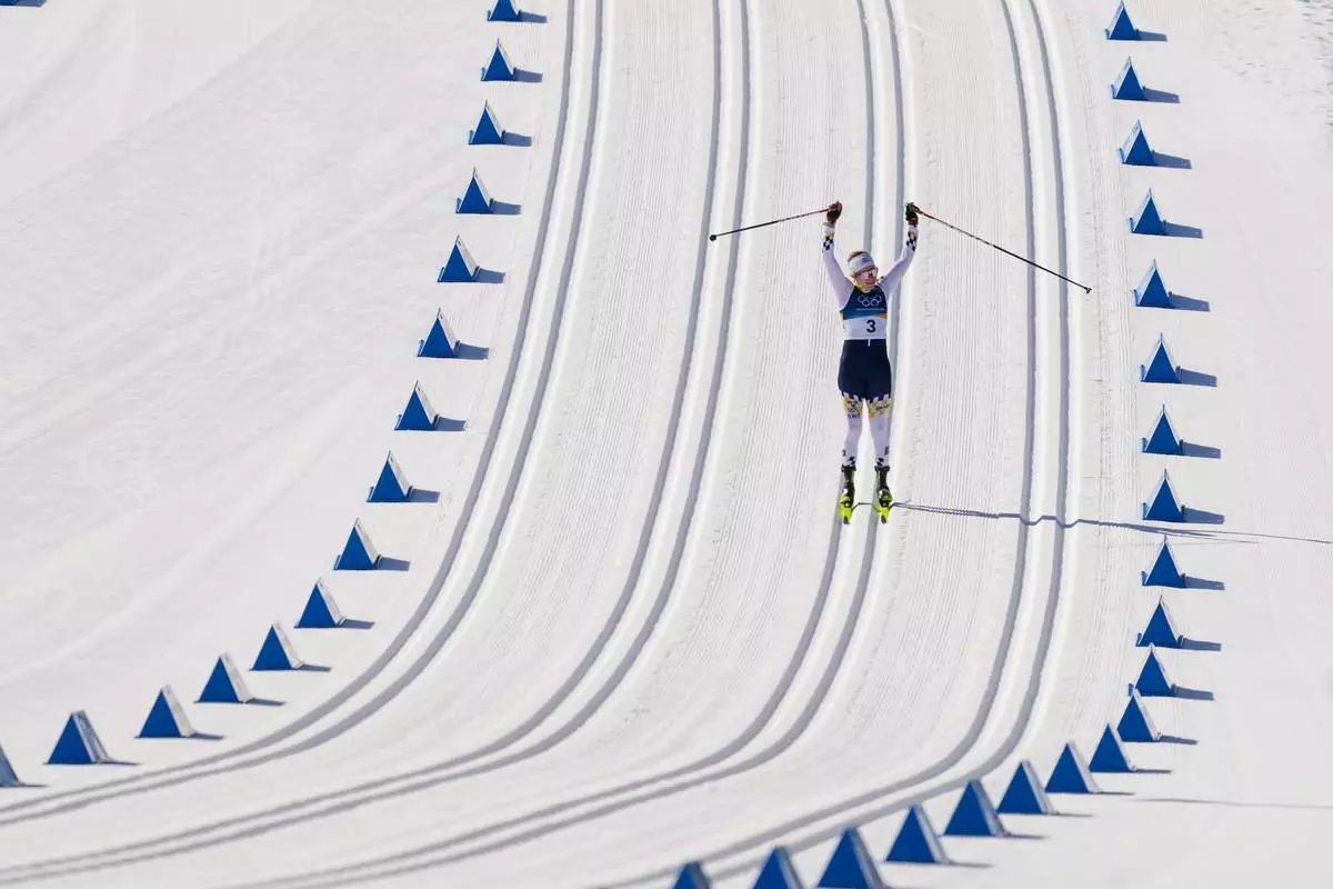 Ebba Andersson, of Sweden, approaches the finish line to win the gold medal in the cross country skiing women's 50km mass start classic at the 2026 Winter Olympics, in Tesero, Italy, Sunday, Feb. 22, 2026. (AP Photo/Evgeniy Maloletka)