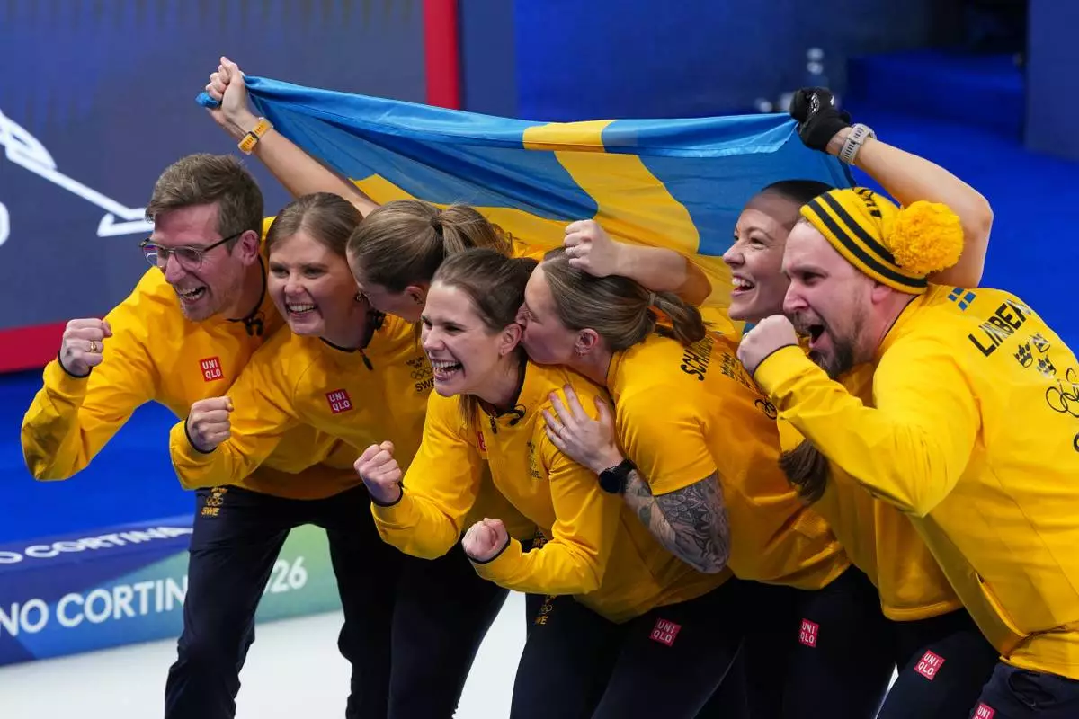 Sweden's Anna Hasselborg, Sara McManus, Sofia Scharback and Agnes Knochenhauer celebrate defeating Switzerland to win a women's curling gold medal match, at the 2026 Winter Olympics, in Cortina d'Ampezzo, Italy, Sunday, Feb. 22, 2026. (AP Photo/Misper Apawu)