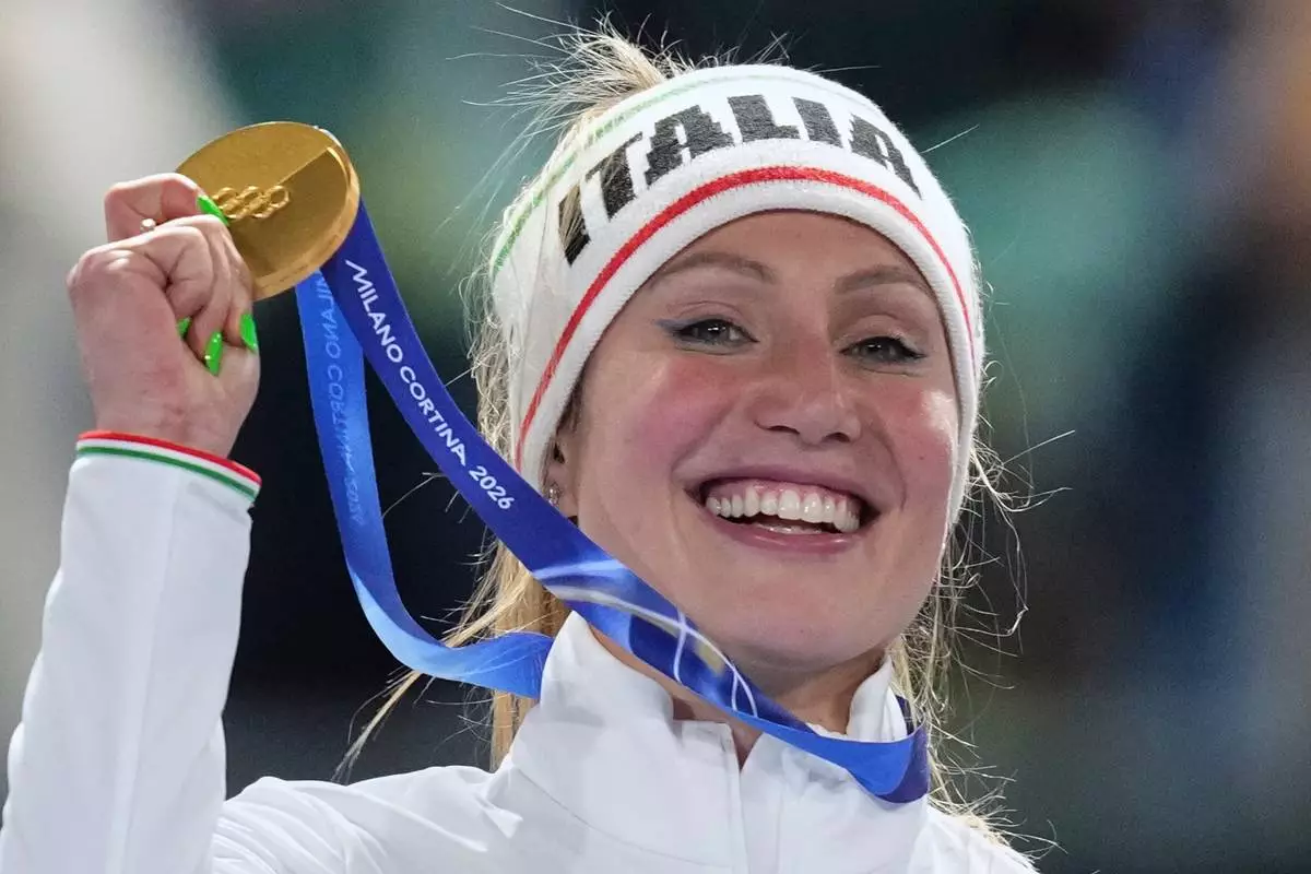 Francesca Lollobrigida of Italy celebrates with her gold medal on the podium of the women's 3,000 meters speedskating race at the 2026 Winter Olympics, in Milan, Italy, Saturday, Feb. 7, 2026. (AP Photo/Christophe Ena)