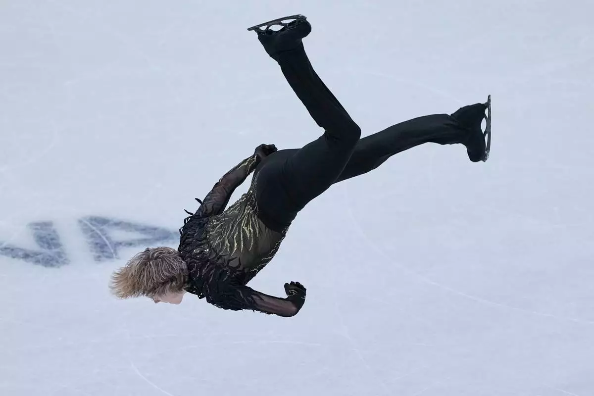 Ilia Malinin of the United States does a back flip while competing during the figure skating men's team event at the 2026 Winter Olympics, in Milan, Italy, Sunday, Feb. 8, 2026. (AP Photo/Natacha Pisarenko)