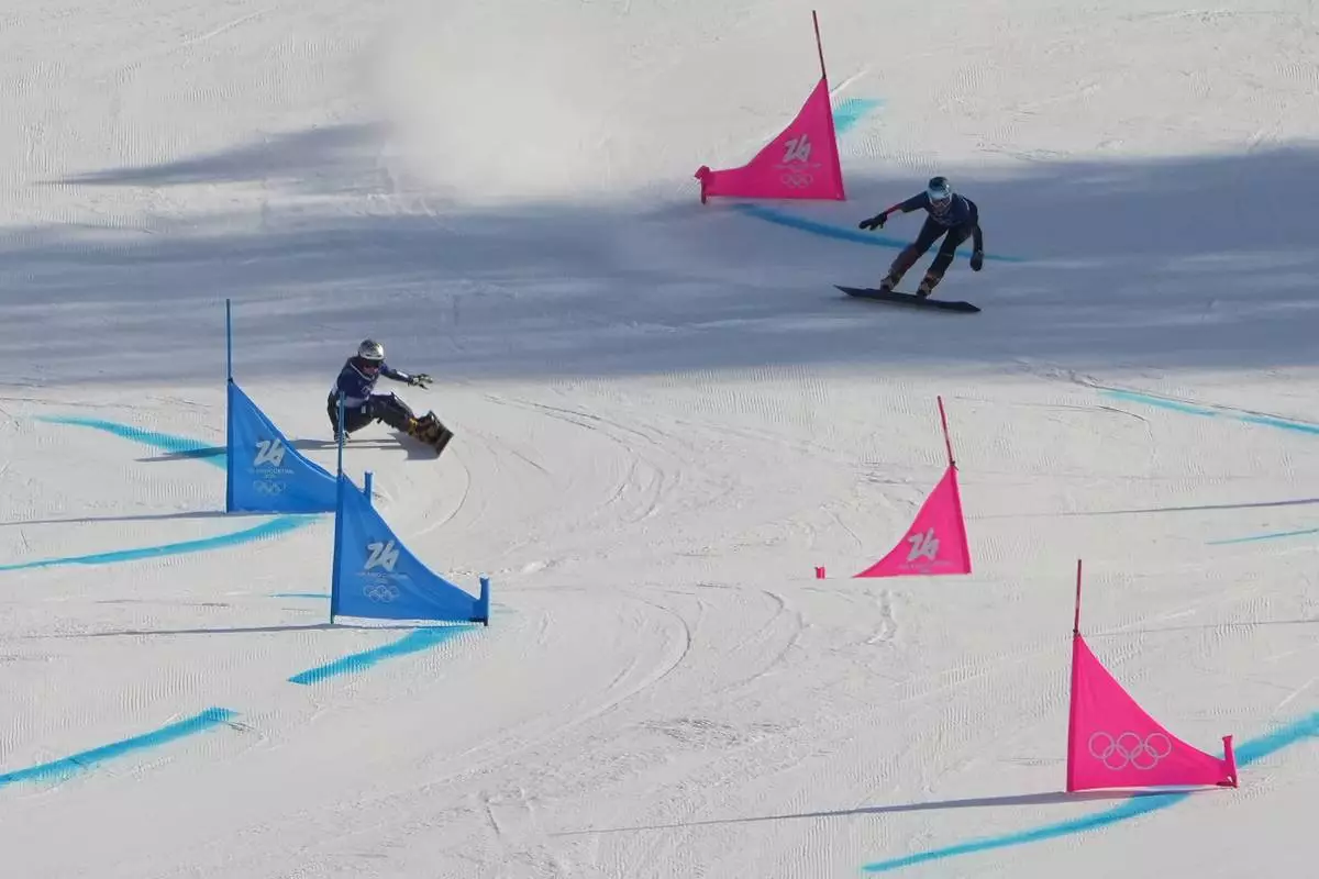 Czechia's Ester Ledecka, left, and Austria's Claudia Riegler compete during the women's snowboarding parallel giant slalom finals at the 2026 Winter Olympics, in Livigno, Italy, Sunday, Feb. 8, 2026. (AP Photo/Lindsey Wasson)