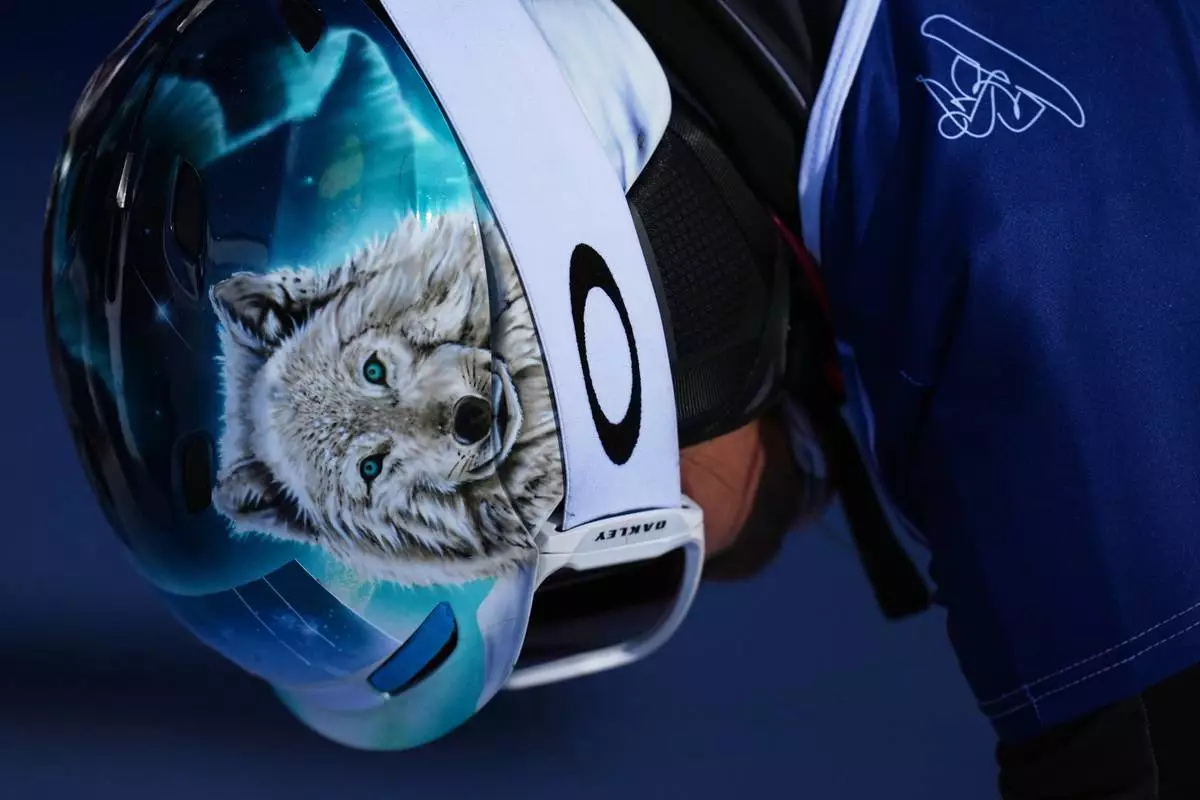 A wolf is displayed on the helmet of Austria's Claudia Riegler as she waits to compete during the women's snowboarding parallel giant slalom qualifications at the 2026 Winter Olympics, in Livigno, Italy, Sunday, Feb. 8, 2026. (AP Photo/Gregory Bull)