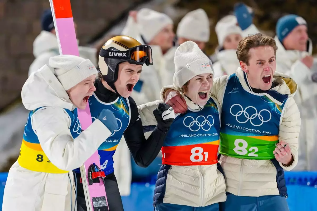 Eirin Maria Kvandal, from left, Marius Lindvik, Anna Odine Stroem, and Kristoffer Eriksen Sundal, of Norway, celebrate after their final round jump during the ski jumping mixed team competition at the 2026 Winter Olympics, in Predazzo, Italy, Tuesday, Feb. 10, 2026. (AP Photo/Kirsty Wigglesworth)