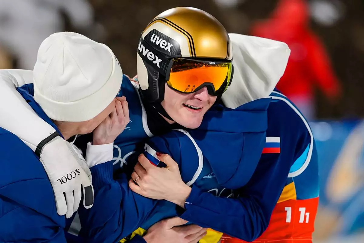 Domen Prevc, center, of Slovenia, celebrates with teammates Nika Vodan, Nika Prevc and Anze Lanisek, after winning the gold medal in the ski jumping mixed team competition at the 2026 Winter Olympics, in Predazzo, Italy, Tuesday, Feb. 10, 2026. (AP Photo/Matthias Schrader)