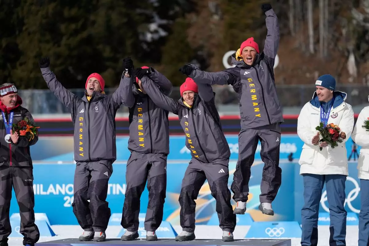 Germany's Erik Lesser, Daniel Boehm, Arnd Peiffer and Simon Schempp, gold medalists for the men's 4x7.5-kilometer biathlon relay race from the 2014 Sochi Winter Olympics celebrate during a reallocation medals ceremony at the 2026 Winter Olympics in Anterselva, Italy, Sunday, Feb. 15, 2026. (AP Photo/Mosa'ab Elshamy)