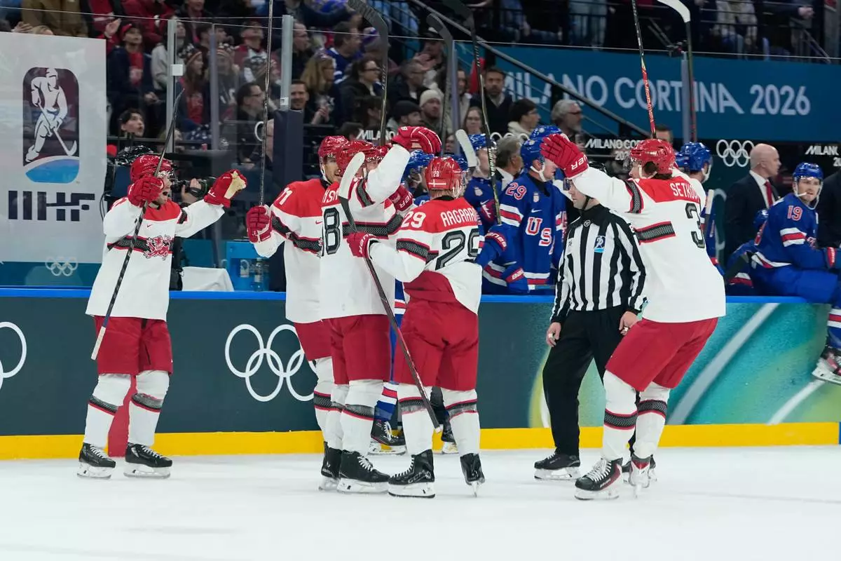 Denmark's Nicholas Jensen celebrates with his teammates after scoring his side's second goal during a preliminary round match of men's ice hockey between United States and Denmark at the 2026 Winter Olympics, in Milan, Italy, Saturday, Feb. 14, 2026. (AP Photo/Petr David Josek)