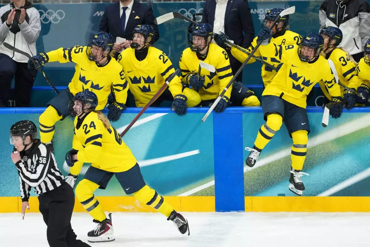Team Sweden players jump from the bench to celebrate after they beat Czechia 2-0 in their women's ice hockey quarterfinal match at the 2026 Winter Olympics, in Milan, Italy, Friday, Feb. 13, 2026. (AP Photo/Carolyn Kaster)