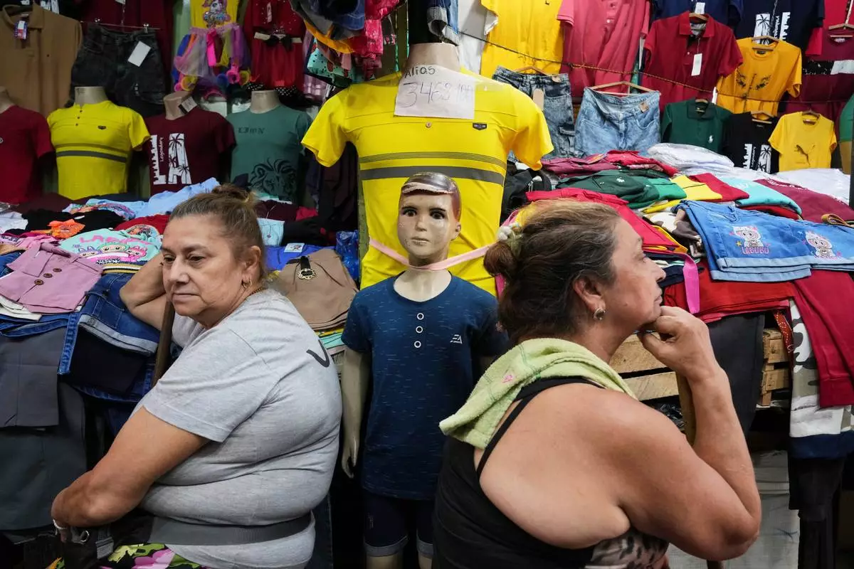 FILE - Vendors wait for customers at a market that primarily sells clothing imported from China in Asuncion, Paraguay, Jan. 31, 2026. (AP Photo/Jorge Saenz)