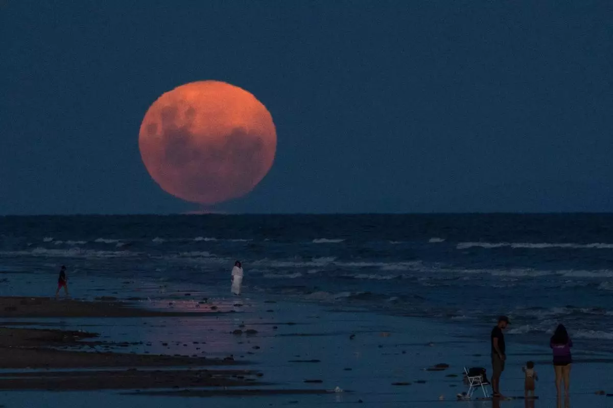 FILE - A full moon rises over Montevideo, Uruguay, Feb. 1, 2026. (AP Photo/Matilde Campodonico, File)