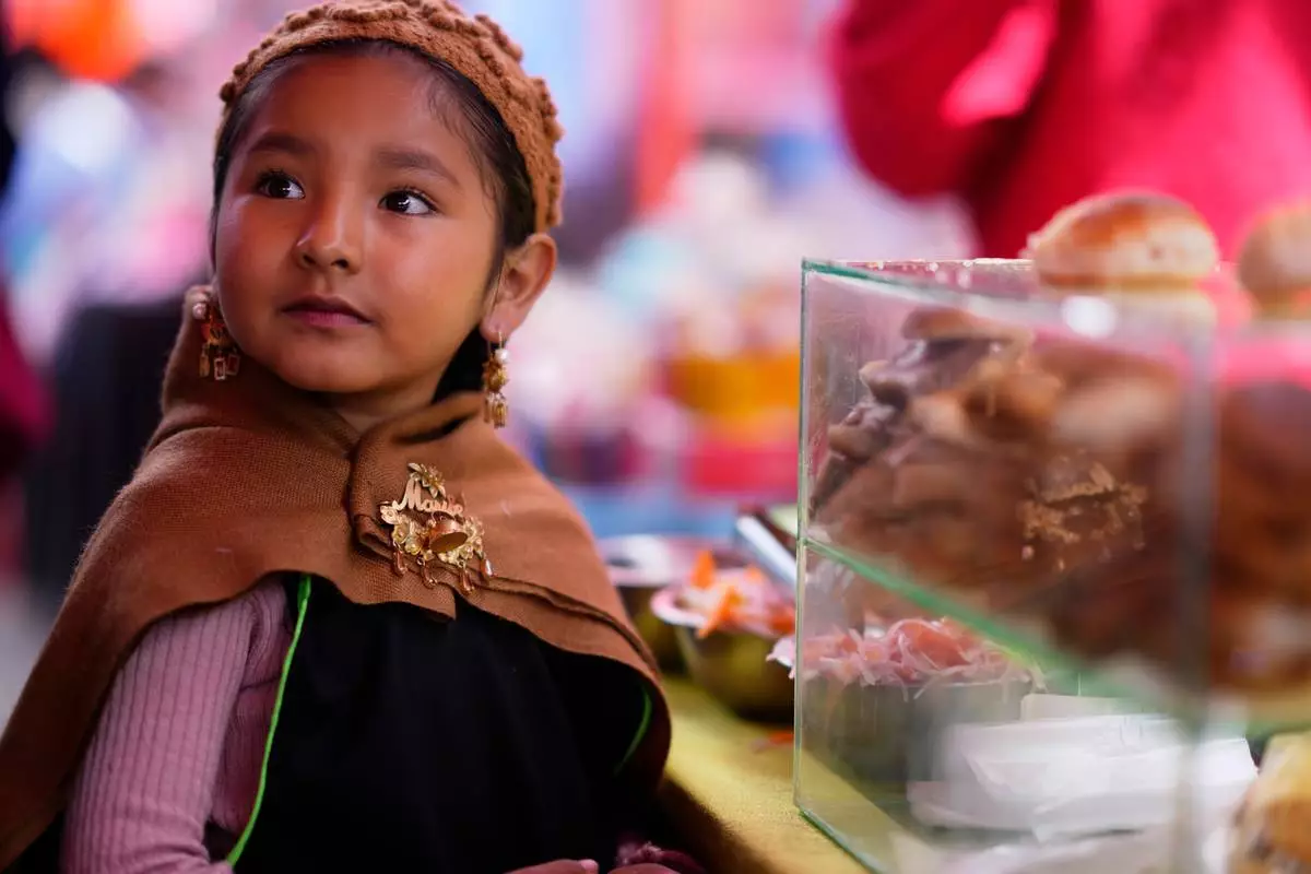 FILE - A young vendor of miniature pork sandwich takes part in the Alasita Children's Fair in La Paz, Bolivia, Feb. 4, 2026. (AP Photo/Juan Karita, File)