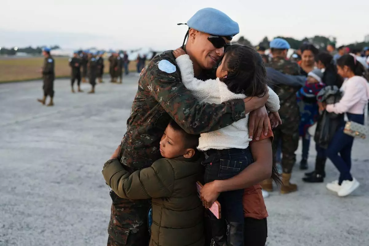FILE - A soldier embraces his family during a farewell ceremony in Guatemala City, Jan. 31, 2026, before traveling to join the United Nations peacekeeping force in the Democratic Republic of the Congo. (AP Photo/Moises Castillo, File)