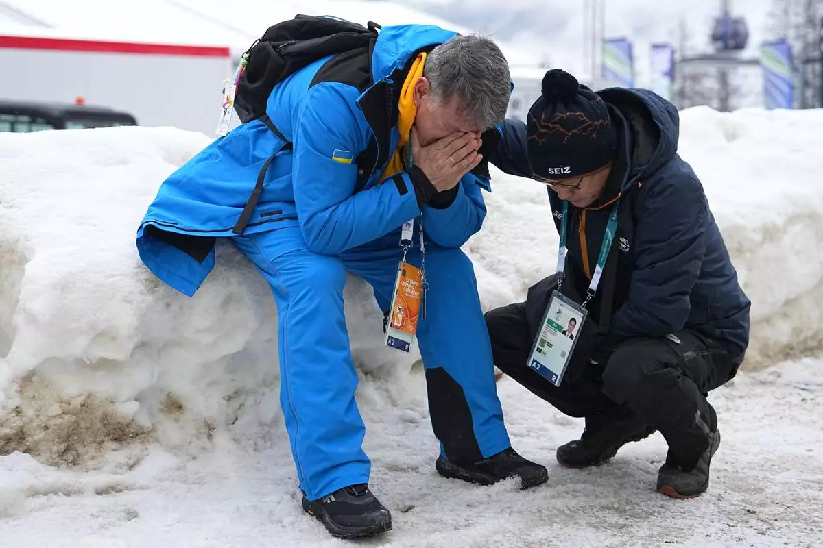 Mykhailo Heraskevych, father of Ukrainian skeleton athlete Vladyslav Heraskevych, reacts as he sits next to the start house of the sliding center at the 2026 Winter Olympics, in Cortina d'Ampezzo, Italy, Thursday, Feb. 12, 2026. (AP Photo/Fatima Shbair)