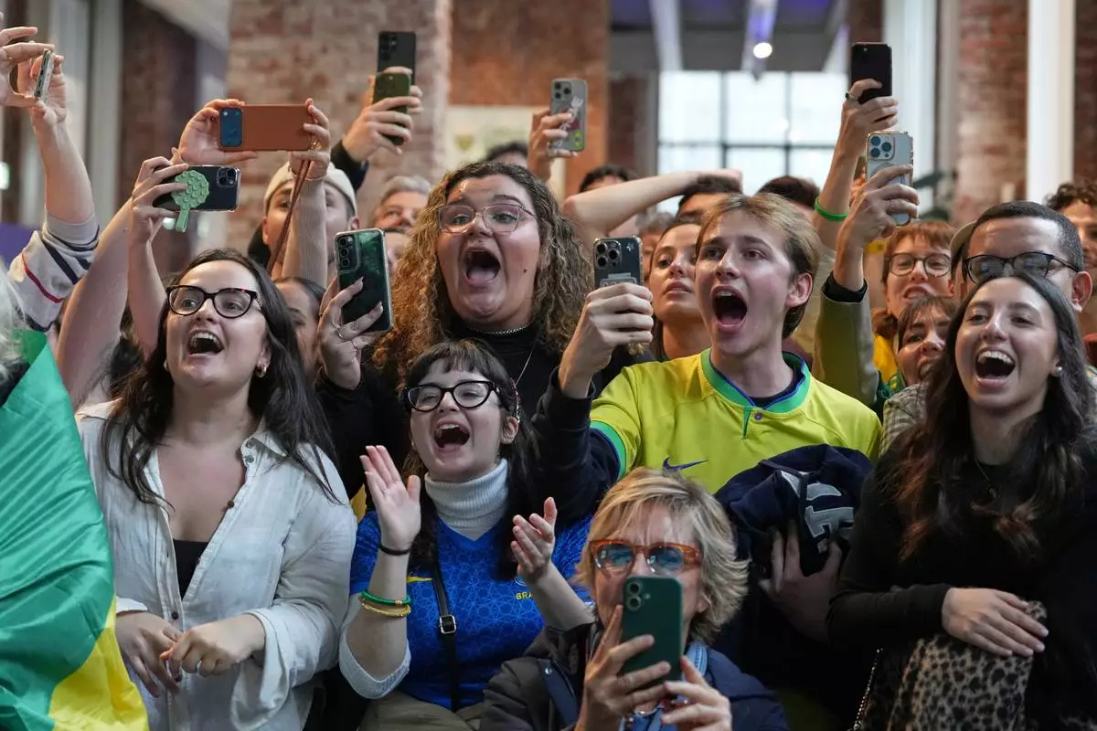 Supporters of Brazil's Lucas Pinheiro Braathen react at the Brazil House as he starts his second run in the men's giant slalom at the 2026 Winter Olympics, in Milan, Italy, Saturday, Feb. 14, 2026. (AP Photo/Antonio Calanni)