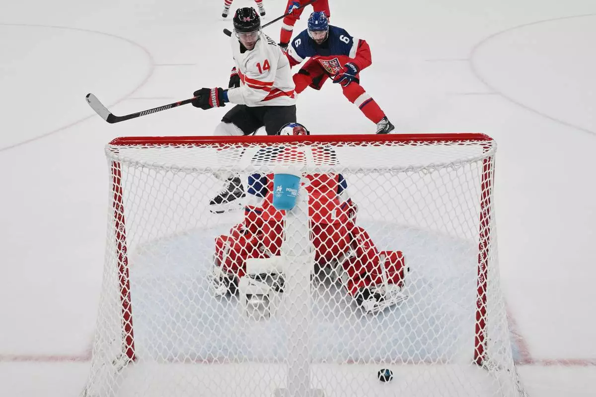Canada's Bo Horvat shoots and scores his team's third goal past Czech Republic's Lukas Dostal, during a preliminary round match of men's ice hockey between Czech Republic and Canada at the 2026 Winter Olympics, in Milan, Italy, Thursday, Feb. 12, 2026. (Alexander Nemenov/Pool Photo via AP)