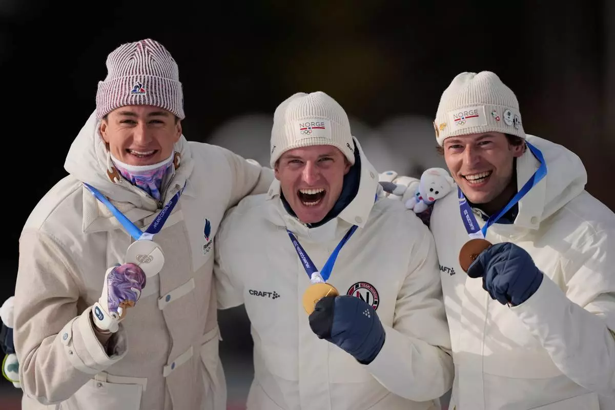 Silver medalist Eric Perrot, of France, from left, gold medalist Johan-Olav Botn, of Norway, and bronze medalist Sturla Holm Laegreid, of Norway, pose after the men's 20-kilometer individual biathlon race at the 2026 Winter Olympics in Anterselva, Italy, Tuesday, Feb. 10, 2026. (AP Photo/Mosa'ab Elshamy)