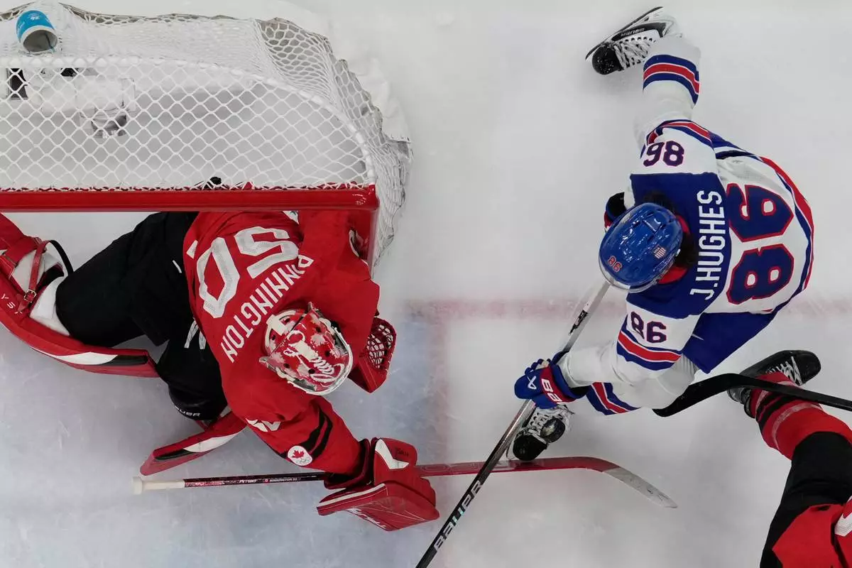 United States' Jack Hughes (86) challenges with Canada's Jordan Binnington (50) during a men's ice hockey gold medal game between Canada and the United States at the 2026 Winter Olympics, in Milan, Italy, Sunday, Feb. 22, 2026. (AP Photo/Petr David Josek)