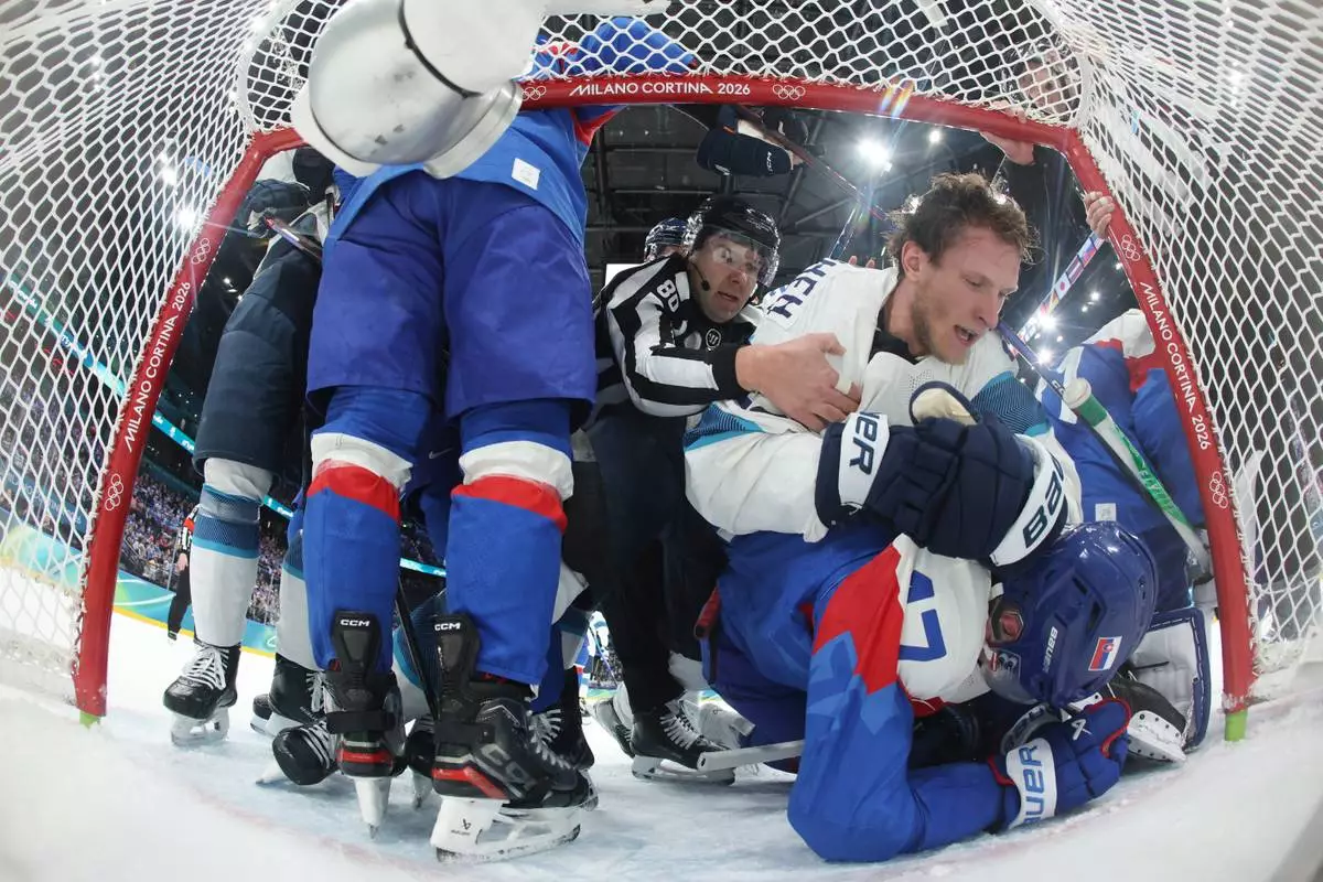 Finland's Eetu Luostarinen (27) top and Slovakia's Simon Nemec (17) bottom scuffle in the second period during a preliminary round match of men's ice hockey the 2026 Winter Olympics, in Milan, Italy, Wednesday, Feb. 11, 2026. (Bruce Bennett/Pool Photo via AP)