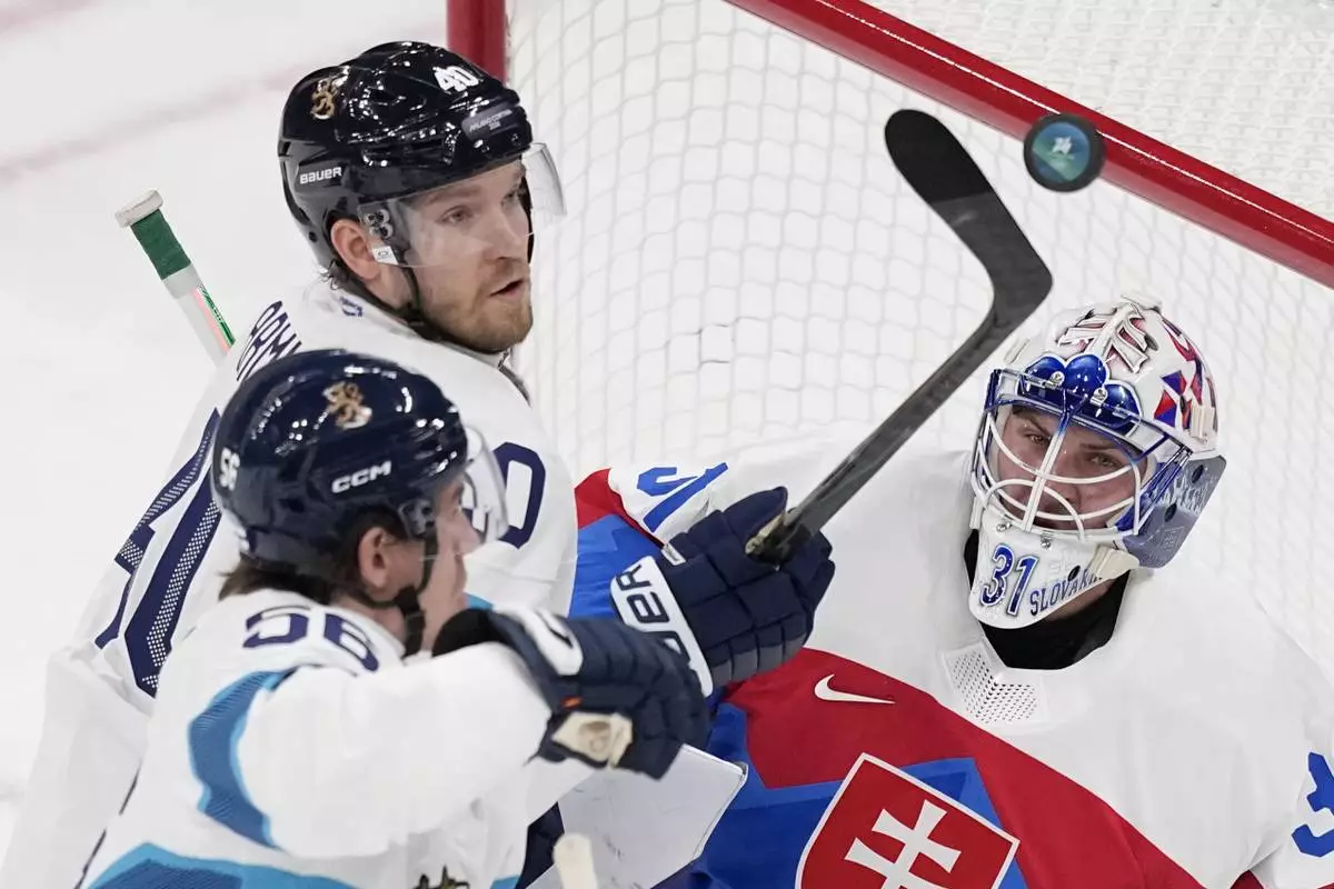 Slovakia's goalkeeper Samuel Hlavaj, right, makes a save against Finland's Joel Armia, center, and Finland's Erik Haula during a preliminary round match of men's ice hockey between Slovakia and Finland at the 2026 Winter Olympics, in Milan, Italy, Wednesday, Feb. 11, 2026. (AP Photo/Petr David Josek)