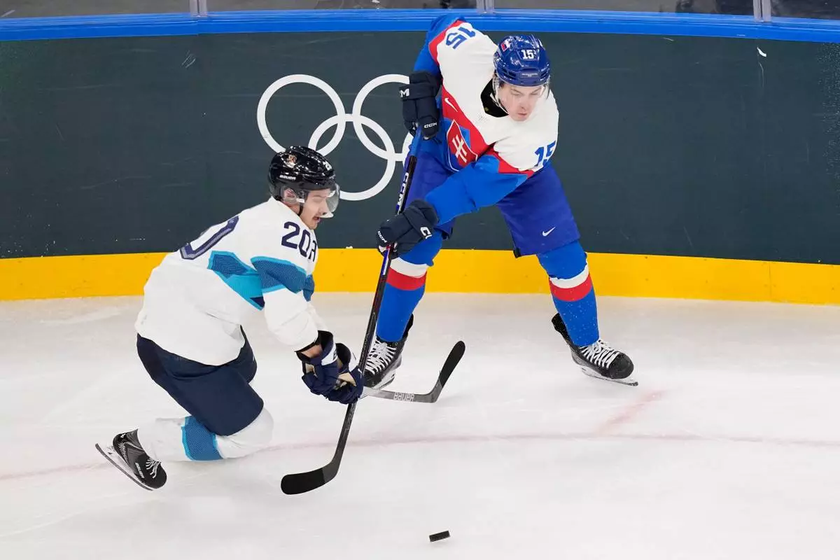 Finland's Sebastian Aho (20), left, challenges Slovakia's Dalibor Dvorsky (15) during a preliminary round match of men's ice hockey between Slovakia and Finland at the 2026 Winter Olympics, in Milan, Italy, Wednesday, Feb. 11, 2026. (AP Photo/Petr David Josek)