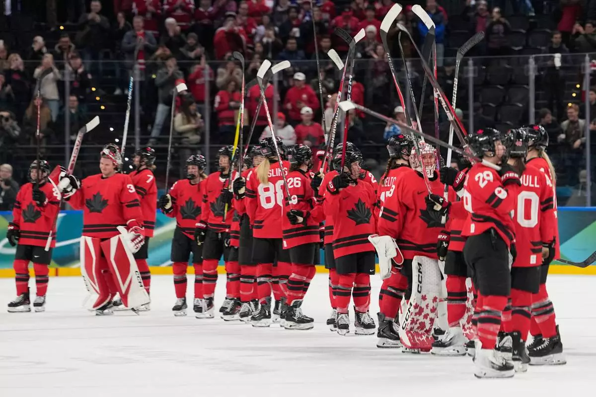 Canada players celebrate victory at the end of a women's ice hockey semifinal game between Canada and Switzerland at the 2026 Winter Olympics, in Milan, Italy, Monday, Feb. 16, 2026. (AP Photo/Hassan Ammar)