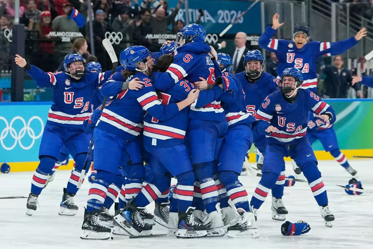 United States' players celebrate after a women's ice hockey gold medal game between the United States and Canada at the 2026 Winter Olympics, in Milan, Italy, Thursday, Feb. 19, 2026. (AP Photo/Petr David Josek)