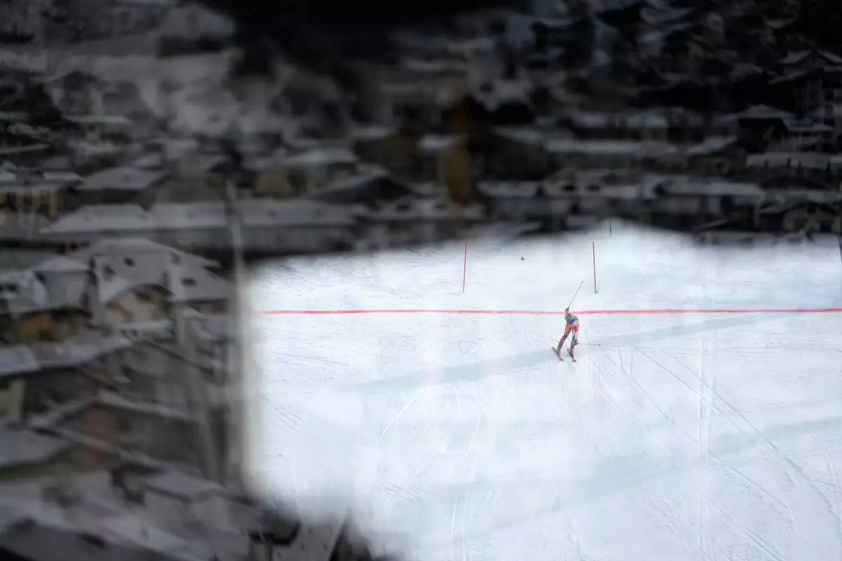 Spain's Joachim Salarich is photographed through a window as he arrives at the finish area during an alpine ski men's slalom race at the 2026 Winter Olympics in Bormio, Italy, Monday, Feb. 16, 2026. (AP Photo/John Locher)