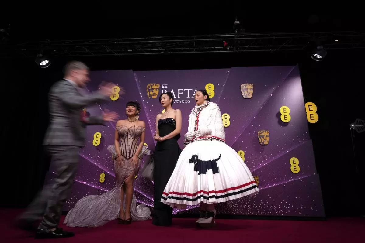 Ejae, from centre left, Audrey Nuna and Rei Ami pose for photographers upon arrival at the 79th British Academy Film Awards, BAFTA's, in London, Sunday, Feb. 22, 2026. (AP Photo/Alastair Grant)