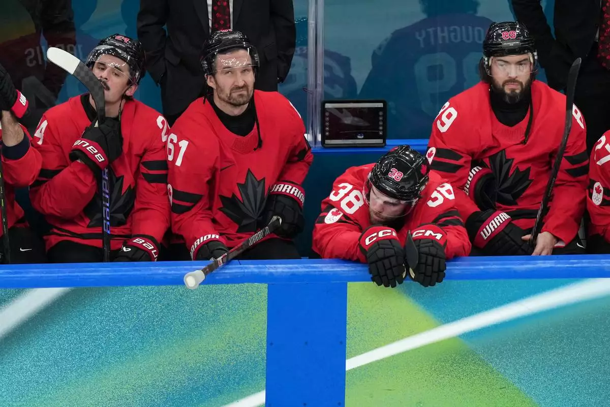 Team Canada players watch as United States players celebrate following the United States' win in the men's ice hockey gold medal game at the 2026 Winter Olympics in Milan, Italy, Sunday, Feb. 22, 2026. (AP Photo/Carolyn Kaster)
