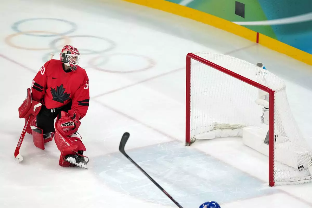 Canada goalkeeper Jordan Binnington looks back at the net as a shot by United States' Jack Hughes gets past for the winning goal in the overtime period of the men's ice hockey gold medal game at the 2026 Winter Olympics in Milan, Italy, Sunday, Feb. 22, 2026. (AP Photo/Carolyn Kaster)