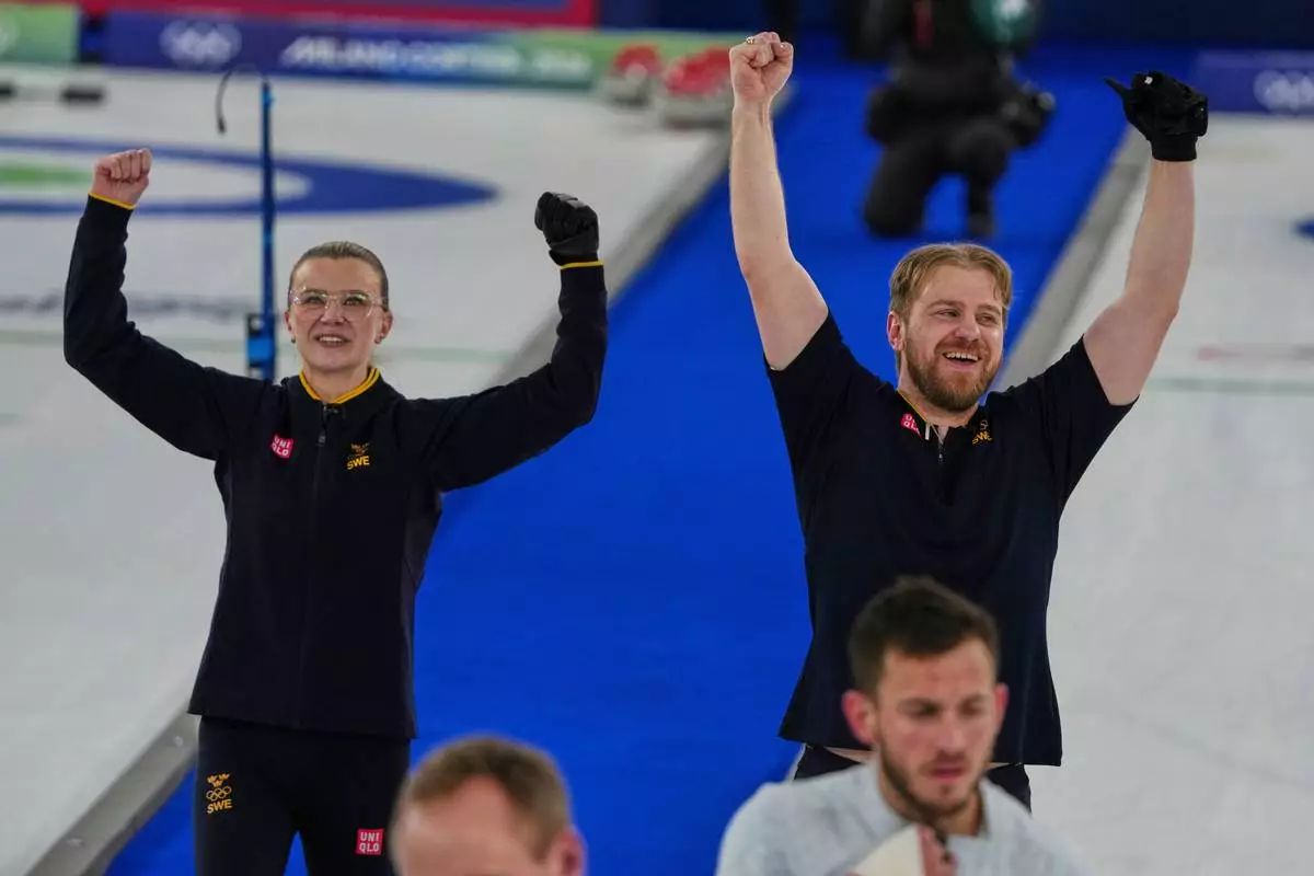Sweden's Rasmus Wranaa and Isabella Wranaa celebrate after winning the gold medal mixed doubles curling match against USA, at the 2026 Winter Olympics, in Cortina D'Ampezzo, Italy, Tuesday, Feb. 10, 2026. (AP Photo/Misper Apawu)