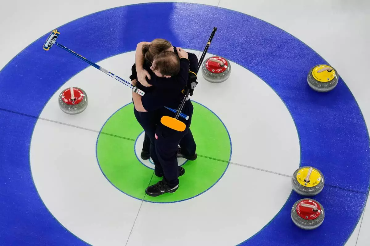 Sweden's Rasmus Wranaa and Isabella Wranaa, left, celebrate after winning the curling mix doubles gold medal match against United States at the 2026 Winter Olympics, in Cortina d'Ampezzo, Italy, Tuesday, Feb. 10, 2026. (AP Photo/Bernat Armangue)