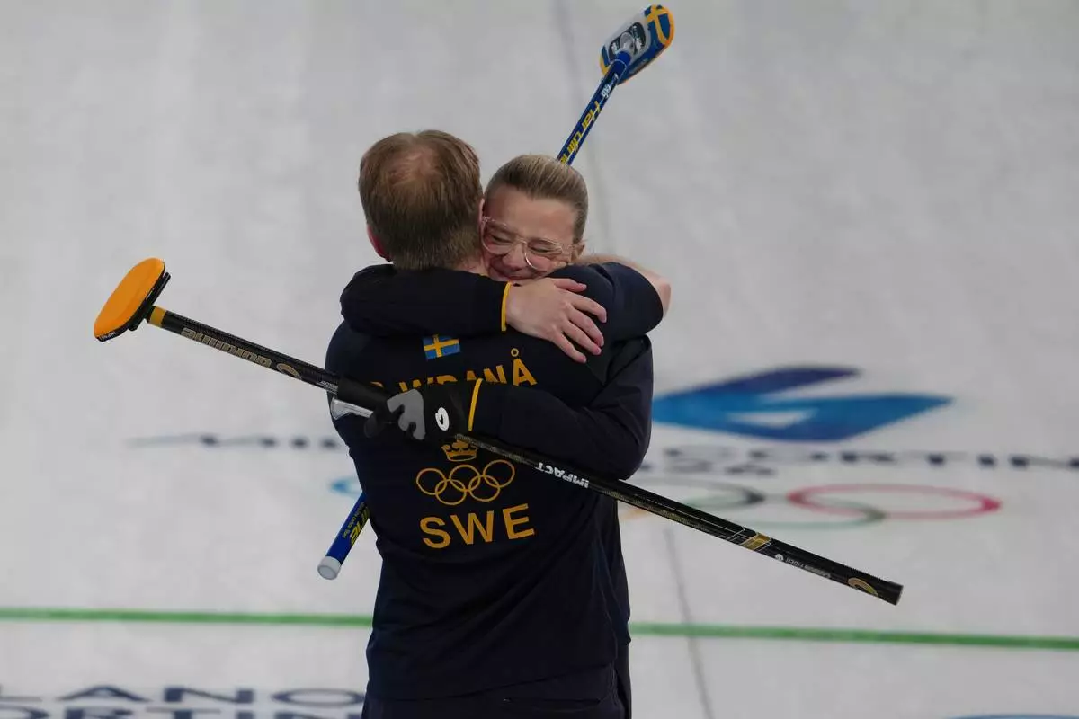 Sweden's Rasmus Wranaa and Isabella Wranaa celebrate after winning the gold medal mixed doubles curling match against USA, at the 2026 Winter Olympics, in Cortina D'Ampezzo, Italy, Tuesday, Feb. 10, 2026. (AP Photo/Misper Apawu)