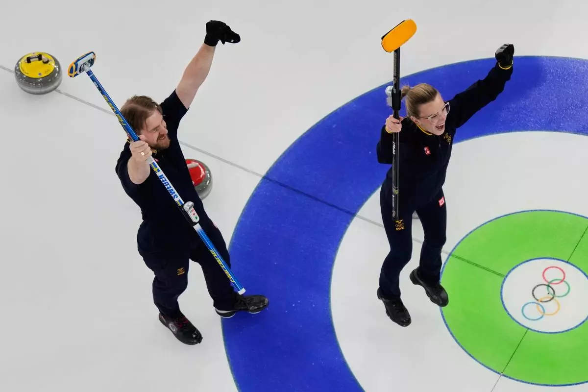 Sweden's Rasmus Wranaa and Isabella Wranaa, right, celebrate after winning the curling mix doubles gold medal match against United States at the 2026 Winter Olympics, in Cortina d'Ampezzo, Italy, Tuesday, Feb. 10, 2026. (AP Photo/Bernat Armangue)