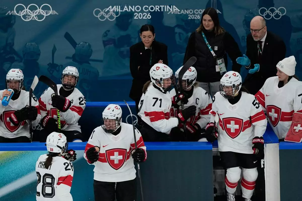 Switzerland's Laura Zimmermann, center, celebrates after scoring her side's opening goal during a preliminary round match of women's ice hockey between Switzerland and Czechia at the 2026 Winter Olympics, in Milan, Italy, Friday, Feb. 6, 2026. (AP Photo/Hassan Ammar)