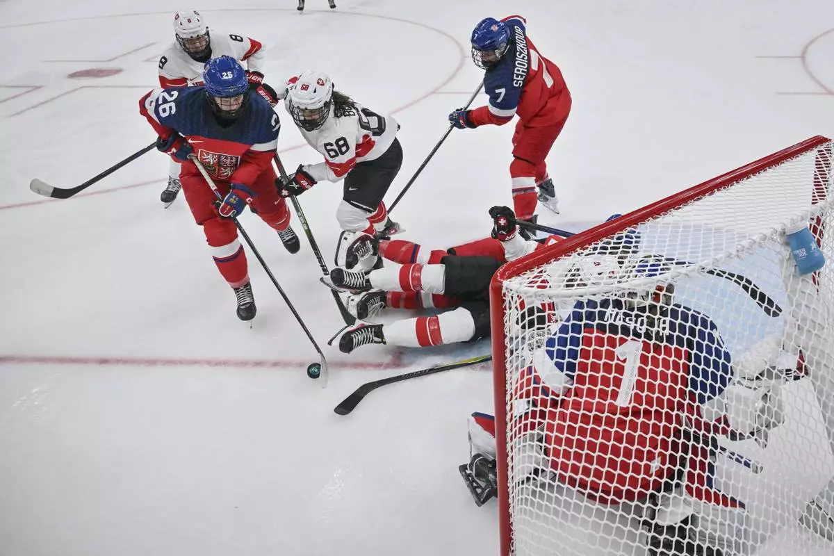 Czechia's forward Vendula Pribylova, left, fights for the puck with Switzerland's forward Leoni Balzer during a preliminary round match of women's ice hockey between Switzerland and Czechia at the 2026 Winter Olympics, in Milan, Italy, Friday, Feb. 6, 2026. (Wikus De Wet/Pool Photo via AP)