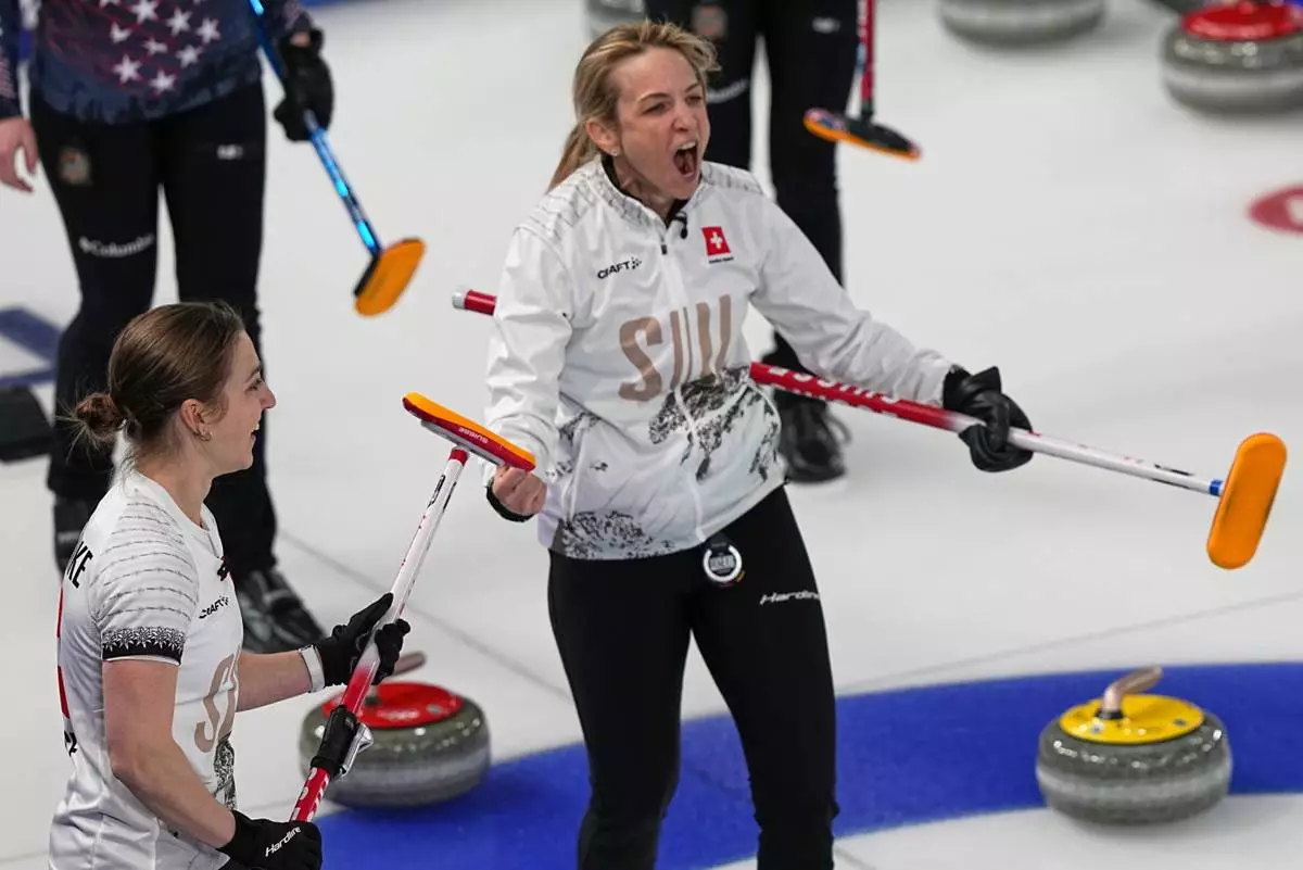 Switzerland's Silvana Tirinzoni, center, and Selina Witschonke celebrate winning a women's curling semifinal match against the United States, at the 2026 Winter Olympics, in Cortina d'Ampezzo, Italy, Friday, Feb. 20, 2026. (AP Photo/Fatima Shbair)